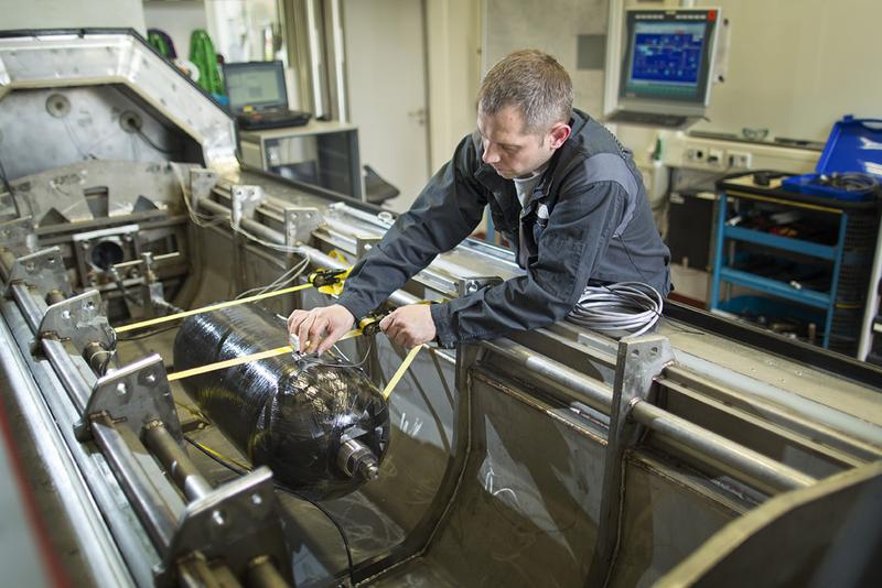 BAM-Prüfingenieur bereitet einen Composite-Druckbehälter für einen Test in der Impulsprüfanlage vor. Quelle: BAM/Thomas Köhler