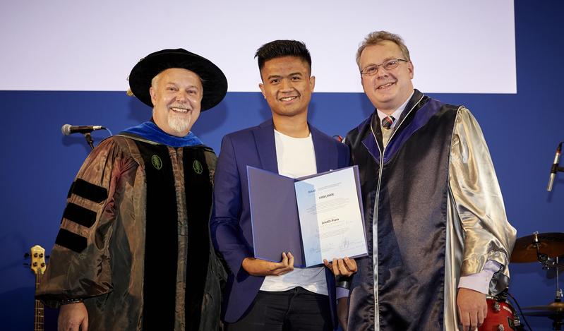 Muhammad Yusuf Azka bei der Verleihung des DAAD-Preises, der ihm von den Dekanen Prof. Dr. Arvid Kappas (links) and Prof. Dr. Werner Nau (rechts) überreicht wurde. 