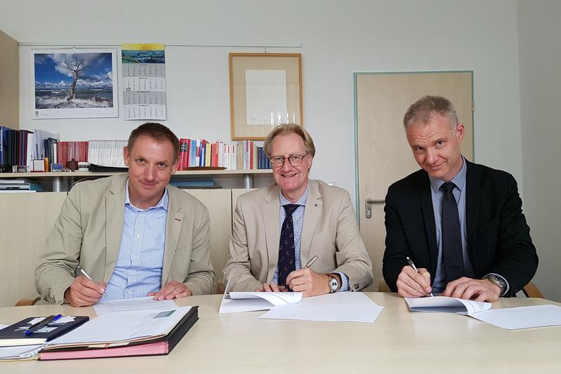 Rektor (m), Prof. Wiegand-Hoffmeister, und Dekan, Prof. Neumann (l), unterzeichnen mit dem geschäftsführenden Vorstandsmitglied des Ostinstitutes Wismar, Prof. Steininger, den Kooperationsvertrag.