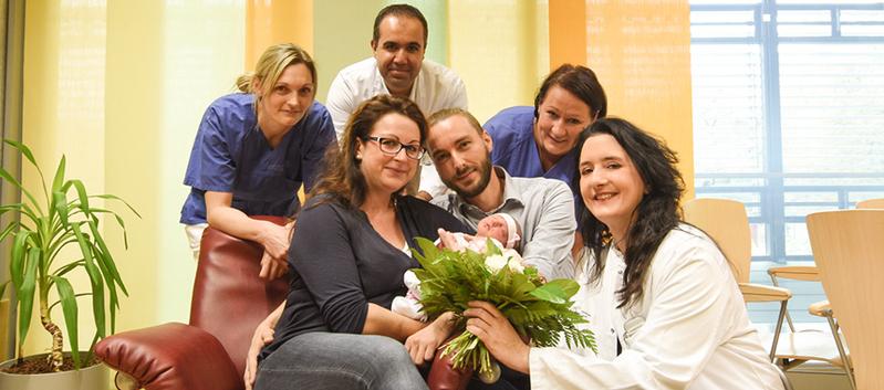 Jacqueline und Martin Hausold (Mitte) freuen sich über Tochter Nora. Mit Klinikleiterin Prof. Pauline Wimberger, Hebamme Sandra Rings, Gynäkologe PD Dr. Birdir sowie Ärztin Theresa Link (v.r.n.l.)