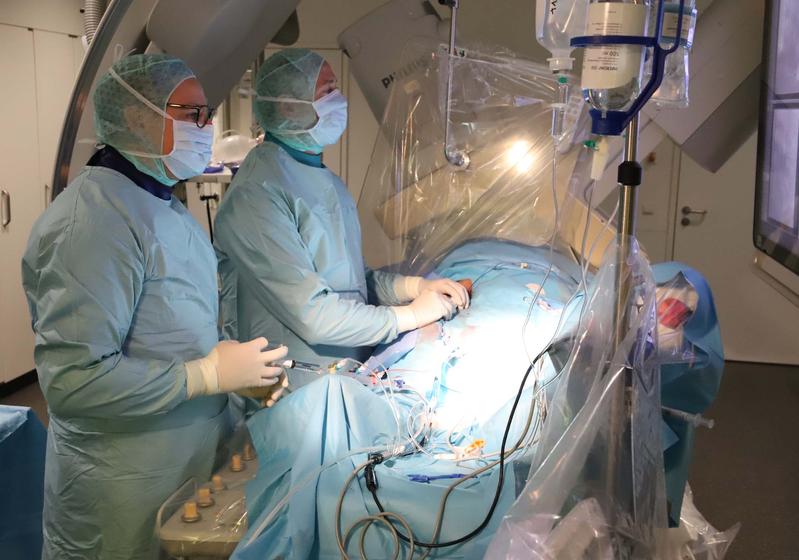 Dr. Alexander Pott (links) und Dr. Tillman Dahme (rechts) führen den ersten Eingriff mit dem neuen Kryoballon im Herzkatheter-Labor des Universitätsklinikums Ulm durch.