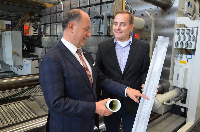 Prof. Lothar Kroll, MERGE-Koordinator (l.), und Mitarbeiter Norbert Schramm über einem sog. Pkw-Dachspriegel. Das Karosseriebauteil wurde aus faserverstärktem Thermoplast in Leichtbauweise gefertigt.