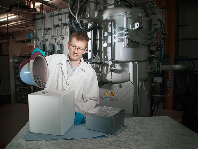 Dr.-Ing. Matthias Trempa, Preisträger des Ulrich-Gösele-Young-Scientist-Awards, beim Befüllen eines Tiegels mit Silizium-Rohstoff. 