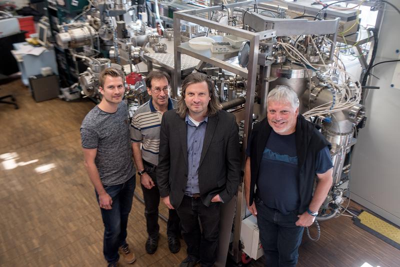  Das Forscherteam Tobias Löffler, Alan Savan, Alfred Ludwig und Wolfgang Schuhmann (von links) vor der kombinatorischen Sputteranlage, in der die Nanopartikelbibliotheken hergestellt wurden