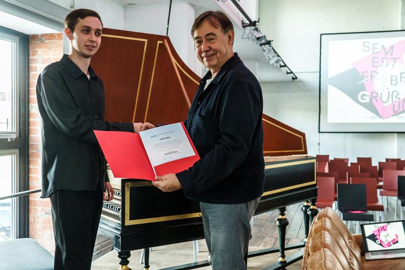 Rektor Roland Lambrette beglückwünscht Preisträger Ilia Kulikov zur diesjährigen Auszeichnung mit dem DAAD-Preis