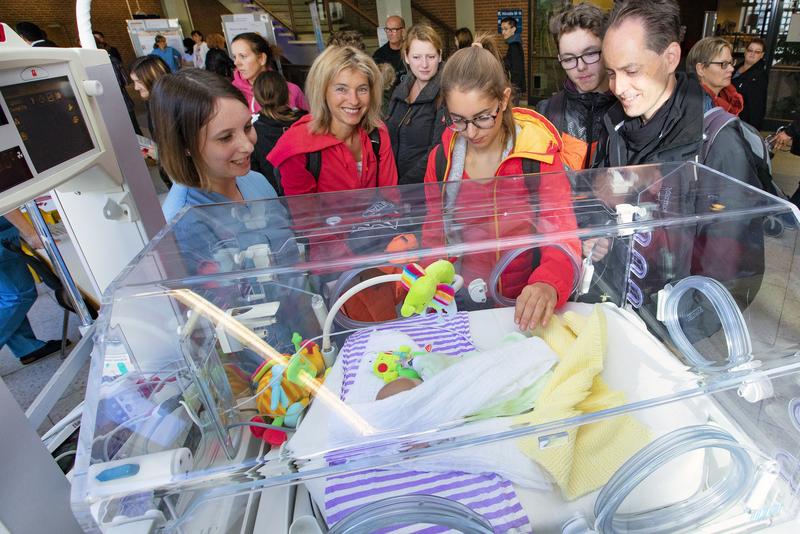 Ein Foto ist angefügt. Es Henrike Meyer (links) von der Station 66 erklärt Familie S. aus Salzgitter anhand einer Puppe, wie frühgeborene Babys in einem Brutkasten versorgt werden. 