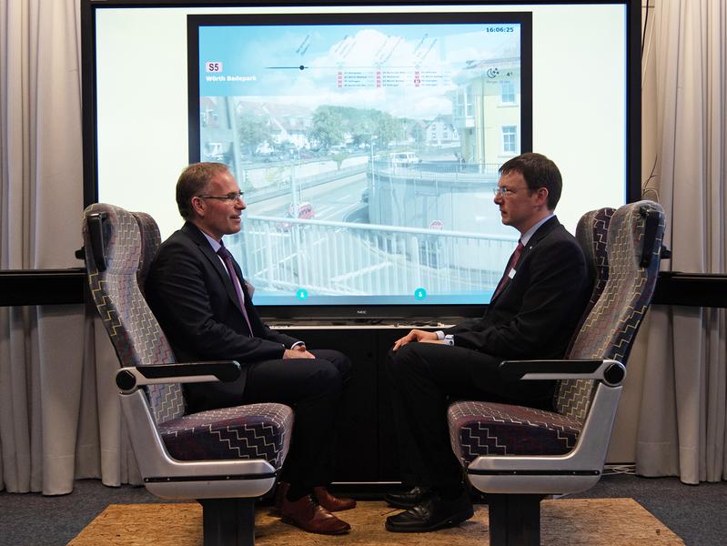 Rektor Prof. Dr.-Ing. Frank Artinger und IUMS-Leiter Prof. Dr.-Ing. Thomas Schlegel vor einem Datenfenster bei Bahnreisen der Zukunft