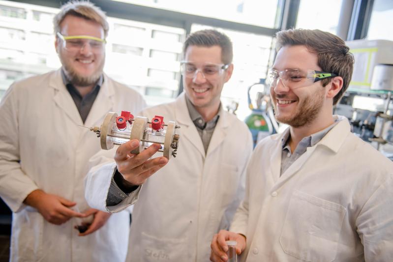 Kai junge Puring, Stefan Piontek und Mathias Smialkowski (von links) aus dem Team von Ulf-Peter Apfel mit der Elektrolysezelle, in der die Experimente durchgeführt wurden