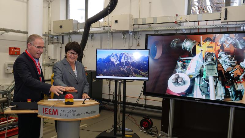 Rektor Prof. Dr. Frank Artinger und OB Cornelia Petzold-Schick starten den Motor des Prüfstands, nachdem in diesem die klimatischen Bedingungen auf der Zugspitze hergestellt wurden