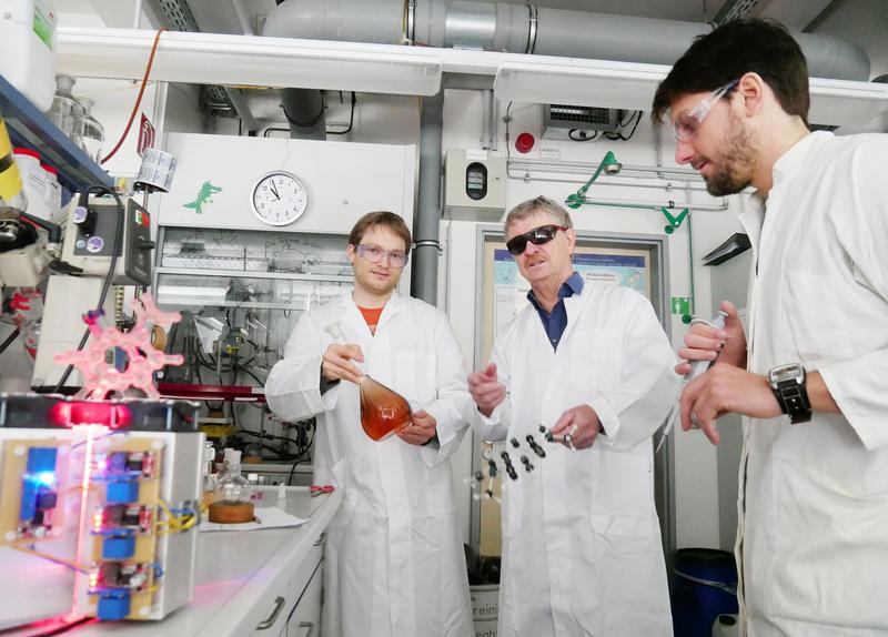 Zusammen mit seinen Doktoranden Kim Steinborn (l.) und Morten Peters hat Prof. Rainer Herges ein eisenhaltiges Molekül entwickelt, dessen magnetische Eigenschaften sich per UV-Licht ändern lassen.