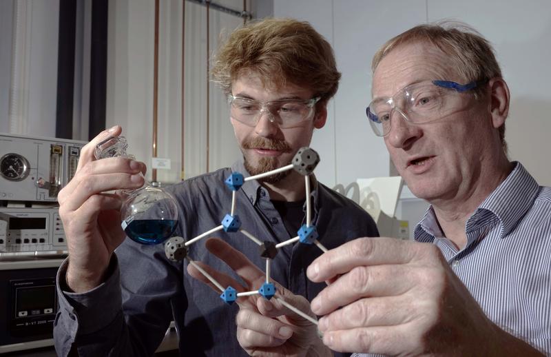 Doktorand Benjamin Kintzel (l.) und Prof. Dr. Winfried Plass diskutieren über ein von ihnen entwickeltes Molekül, das möglicherweise in einem Quantencomputer Verwendung finden kann. 