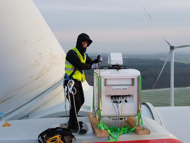 Ein ForWind-Wissenschaftler installiert das laser-optische Lidar-Messgerät zur Erfassung der Nachlaufströmung auf der Gondel einer Windenergieanlage der Firma eno energy. 