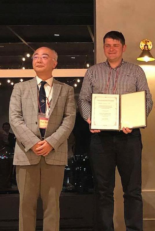 Prof. Dr. Koji Sueoka, Vorsitzender des Organisationskomitees des Forums für Wissenschaft und Technologie von Siliziummaterialien und Dr. Dawid Kot vom IHP (r.) bei der Preisverleihung in Okayama.