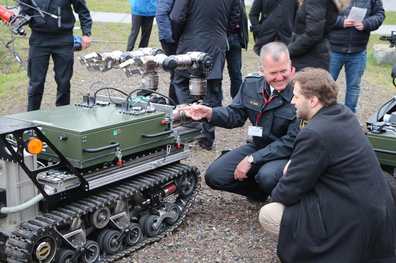 Beeindruckende Technik: A-DRZ-Projektkoordinator Dr. Hauke Speth (li.) ließ sich vor Ort von FKIE-Projektleiter Thomas Barz in die vielfältigen Fähigkeiten einer Roboterplattform einführen.