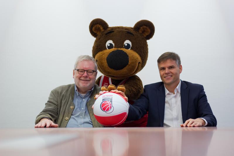 Universitätspräsident Godehard Ruppert (l.) und Brose Bamberg Geschäftsführer Niklas Beyes freuten sich mit Freaky über den neuen Kooperationsvertrag.