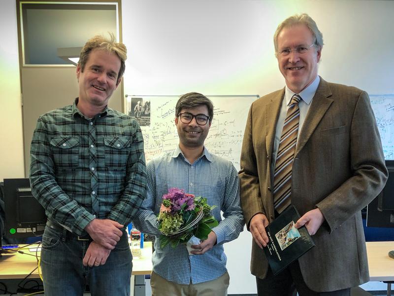 Dr. Olthoff (rechts) und Prof. Stricker (links) überreichten Herrn Ali ein Blumenbouquet und ein Buchpräsent zu diesem erfreulichen Anlass.