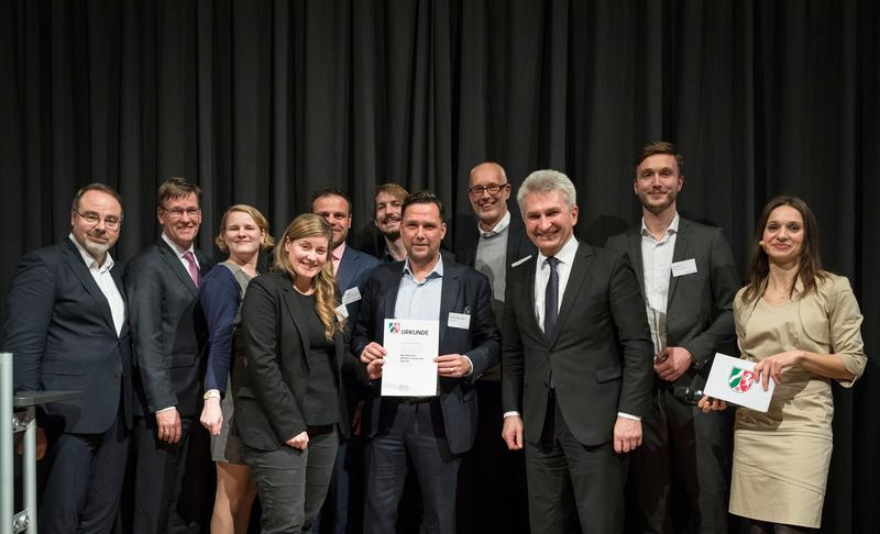 NRW-Minister Prof. Dr. Andreas Pinkwart (3.v.r.) überreicht dem WWU-Team mit Rektor Prof. Dr. Johannes Wessels (2.v.l.) und Projektleiter Prof. Dr. Thorsten Wiesel (5.v.l.) an der Spitze eine Urkunde