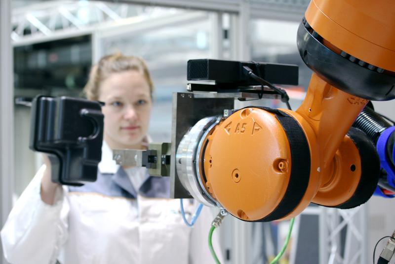 Der Roboter erkennt das Bauteil, das die Mitarbeiterin hält.