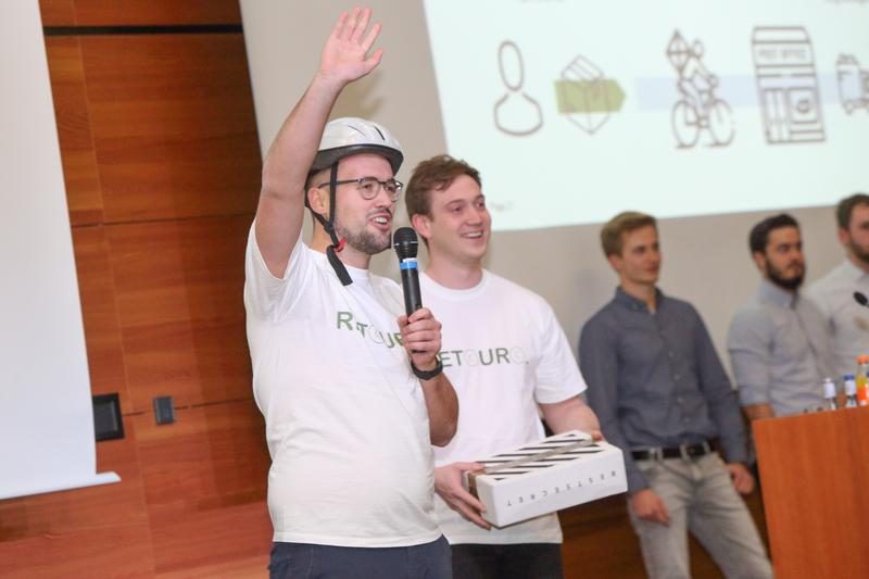 Die Studierenden David Heid (links) und Robin Bässler (rechts) präsentieren ihre Idee „Retouro – Wir erledigen Ihre Retoure: SMART und GRÜN!“ beim Ideenwettbewerb „stAArt-UP!de Challenge 2018“.