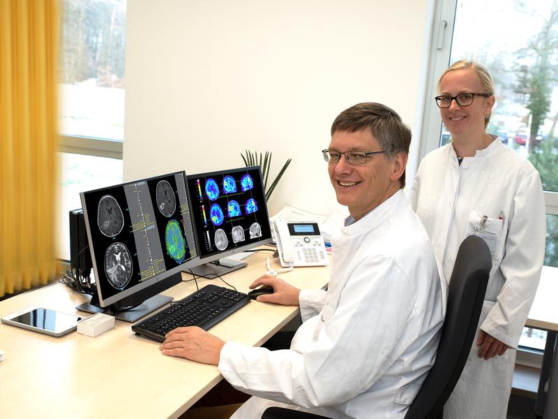 Prof. Dr. Ulrich Herrlinger and Dr. Christina Schaub with pictures of a glioblastoma patient after combination therapy. 