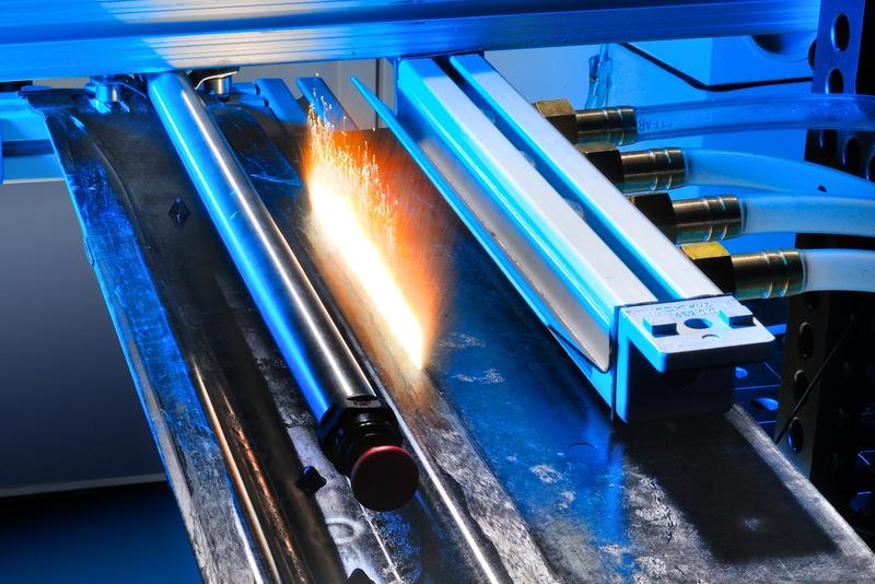 Trimming of a hybrid car roof bow made of glass and carbon-fiber reinforced plastic.