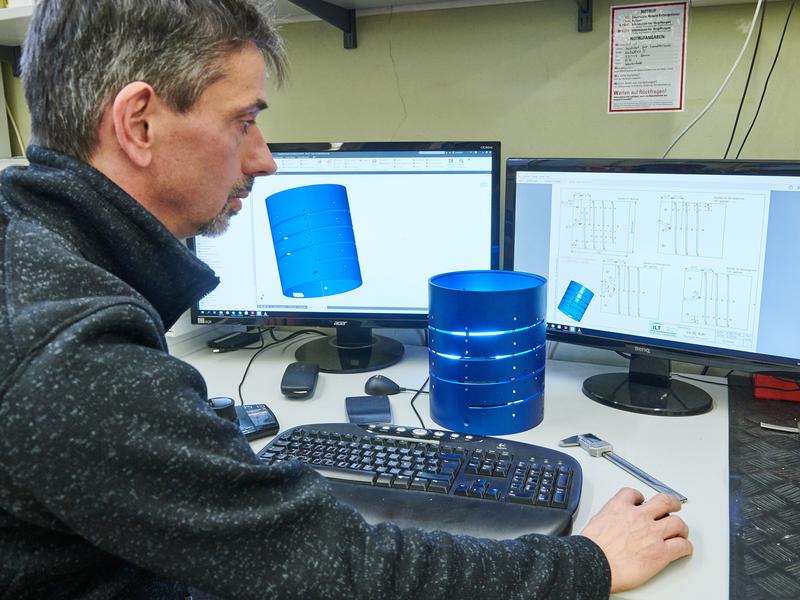 Der Konstrukteur Wilfried Berchtold mit dem Helix-Turm, der Trägerstruktur der Heizspirale für den neuartigen Gaschromatographen. 