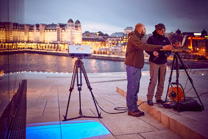 Max Rahrig untersucht mit Kollegin Anna Luib eine Testfläche am Opernhaus in Oslo.