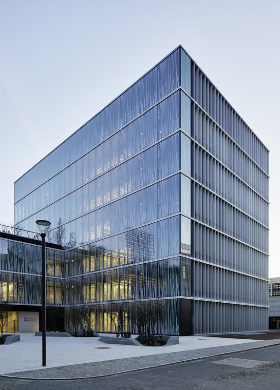 Der winkelförmige Bau von Staab Architekten besitzt eine halbdurchlässige Glasfassade