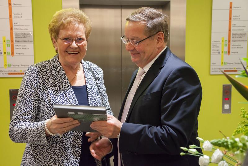 Der Kaufmännische Direktor des UKS Ulrich Kerle überreicht der saarländischen Gesundheitsministerin Monika Bachmann den IMED-Bildband anlässlich der Eröffnung des Gebäudes.