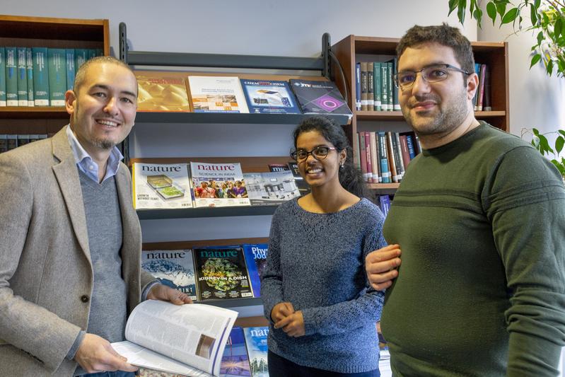 Prof. Dr. Guido Pupillo (left), scientific director of QUSTEC, talking to doctoral students. 