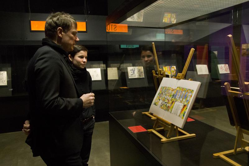 Michael Fischer-Art und Kuratorin Laura Rosengarten in der Ausstellung "Studium – Reisen – Projekte. Skizzenbücher von Fischer-Art" in der Bibliotheca Albertina. 