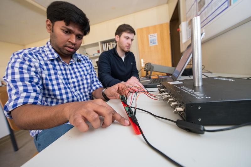 Melvin Chelli (l.) und Fabian Laurent (r.), wissenschaftliche Hilfskräfte im Team von Uwe Hartmann, bereiten den Magnetfeldsensor für die Messe vor.