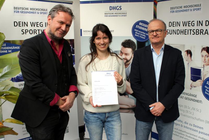 Die erste Life Coaching Absolventin erhält ihr Bachelor-Zeugnis (vlnr: Studiengangsleiter Prof. Dr. Sven Sohr, Marina Maßnick, Präsident der DHGS Prof. Dr. Franz-Michael Binninger)