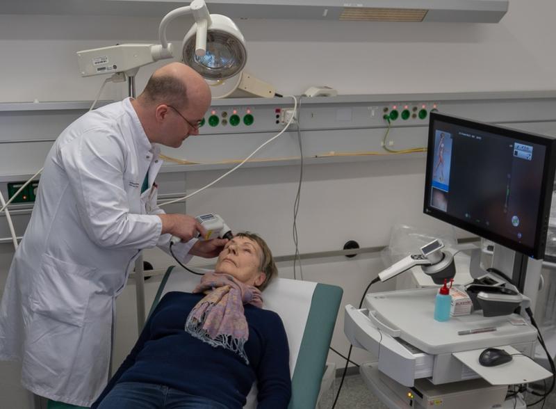 Dr. Jörg Laske, Oberarzt an der Klinik für Dermatologie untersucht an der Stirn einer Patientin ein auffällige Hautstelle mit dem neuen Laser-Mikroskop. 