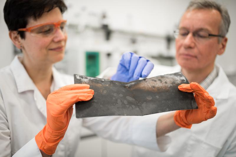 Prof. Jörg Acker und die wissenschaftliche Mitarbeiterin Jana Ducke untersuchen eine Kathodenfolie, die aus einer Lithium-Ionen-Batterie eines Elektroautos nach dessen Demontage entnommen wurde.