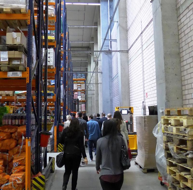 Logistik-Studierende bei einer Exkursion im Hochregallager eines Lebensmittelhändlers 