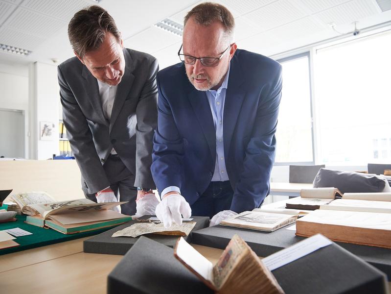 Books are back ULB director Dr. Ulrich Meyer-Doerpinghaus (left) and Dr. Michael Herkenhoff assess the returned books. 