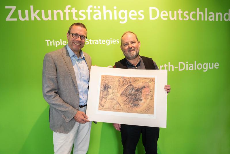 Prof. Dr. Uwe Schneidewind und Ulrich Klan zeigen eine Werkszeichnung der Wuppertaler Künstlerin Ulle Hees "Das zerbrochene Herz – Stele für Else Lasker-Schüler" aus dem Jahr 2000.
