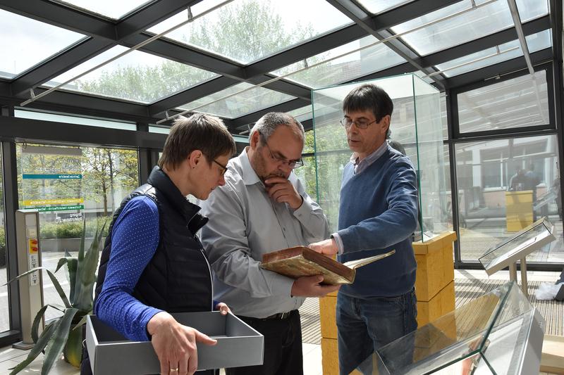 V.l.: Andrea Heist, Leiterin der Hochschulbibliothek (mit dem Transportbehälter für die Originalbücher), Rektor Prof. Dr. Steffen Teichert und THULB-Werkstattleiter Frank Schieferdecker