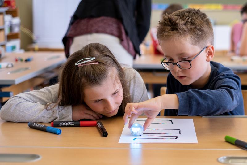 Neben Zettel und Stift befinden sich im Informatikkoffer auch kleine, runde Lernroboter, sogenannte „Ozobots“.