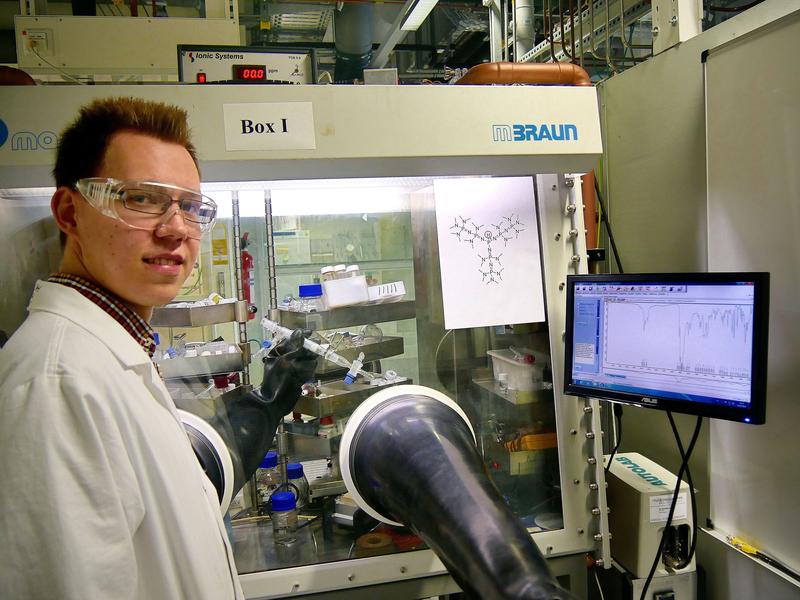 Der Marburger Chemiker Sebastian Ullrich präsentiert eine isolierte Probe seiner Superbase in einem Handschuhkasten, der mit Stickstoff als Schutzgas gefüllt ist.