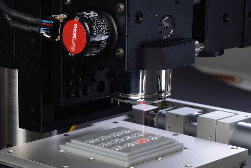 OCT scanning head with lens tray for shape and centering measurement of injection molded micro lenses