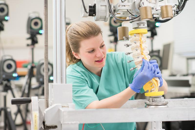 Doctoral candidate Laura Zengerle uses a synthetic model to demonstrate how the spinal load simulator works