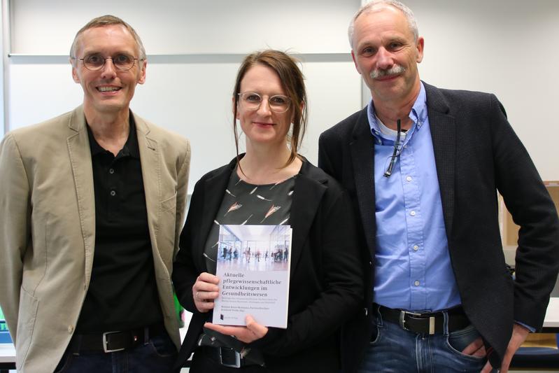 Prof. Dr. Reinhold Wolke (Esslingen), Prof. Dr. Patrizia Raschper (Bielefeld) und Prof. Dr. Mathias Bonse-Rohmann (Hannover) mit dem Buch (von links). 