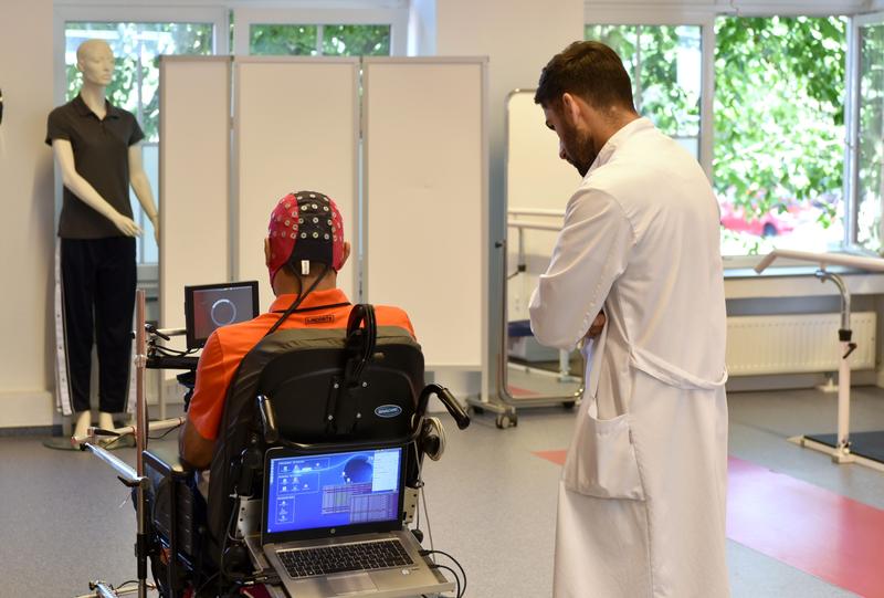 Patient mit Querschnittlähmung steuert den Rollstuhl mit seinen Gedanken.