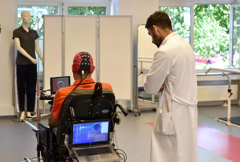 Patient mit Querschnittlähmung steuert den Rollstuhl mit seinen Gedanken.