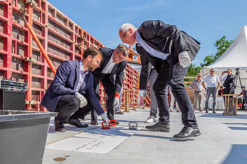 Jenas Oberbürgermeister Thomas Nitzsche, Universitätspräsident Walter Rosenthal und HKI-Direktor Axel Brakhage (v.l.) verschließen die Bodenöffnung mit dem Grundstein.