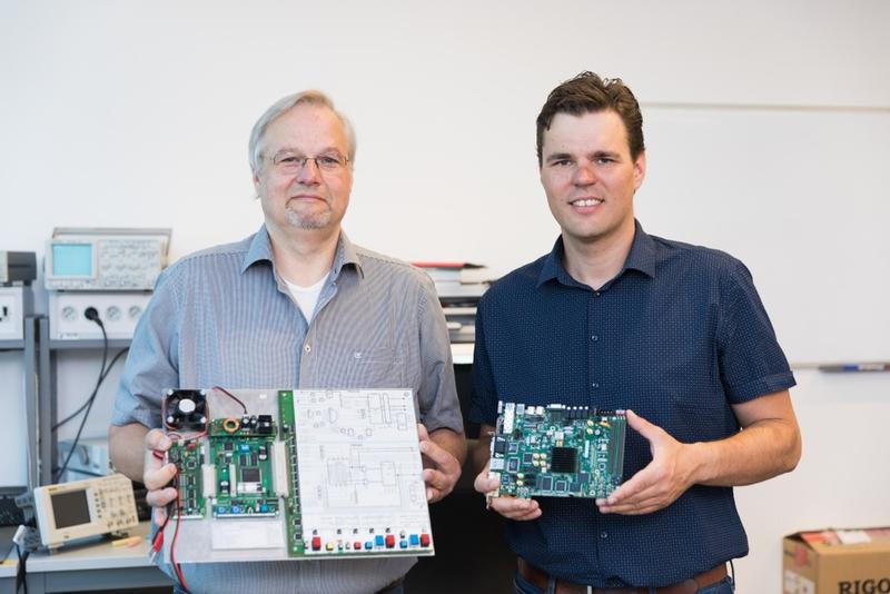 Prof. Dr. Martin Bogdan (links) und Jörn Hoffmann mit am Lehrstuhl eingesetzter Hardware zur Ausbildung sowie Forschung.