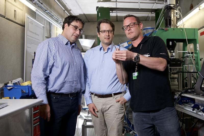 Christian Grünzweig, David Mannes und Techniker Jan Hovind (von links) mit einer Sprengschnur, die sie mit Neutronen durchleuchtet haben.