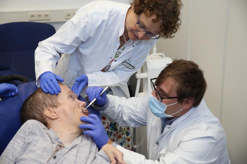 Oberarzt Dr. Peter Schmidt und Zahnärztin Dr. Gisela Goedicke-Padligur behandeln Patient Marko